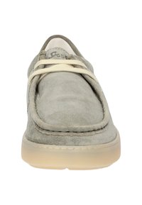 Chaussure en suède gris avec un bout arrondi, des lacets élastiques et une semelle en caoutchouc de couleur claire; présente des coutures le long du bord supérieur.