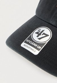 Zwarte verstelbare honkbalpet met een ronde witte en zwarte '47 Clean Up logo sticker op de klep tegen een witte achtergrond.