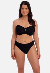 Ensemble de bikini noir comprenant un haut sans bretelles avec un design froncé et un accent doré, et un bas taille haute en tissu texturé.