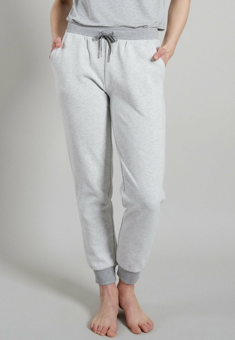 Pantaloni jogger grigio chiaro realizzati in tessuto morbido. Presentano una vita elasticizzata, chiusura con coulisse e orli a costine con accenti grigi.