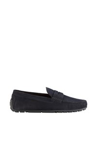 Mocasin de ante azul marino con un acento trenzado en la parte superior, suela de goma y detalles cosidos en los bordes. Textura suave.