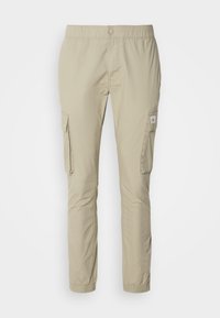 Beige cargo kalhoty vyrobené z lehkého materiálu, s elastickým pasem, dvěma postranními cargo kapsami a úzkým tapered střihem.