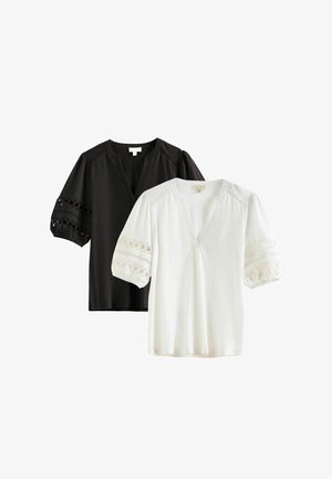 To korte ærmeløse bluser med v-hals, en sort og en hvid, begge med puffede ærmer og blonderiudskæringer.