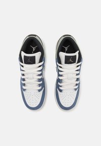 Vita och marinblå sneakers med perforerat tåparti, svarta accenter och textilsnören. Har en logo på tungan och en texturerad krage.