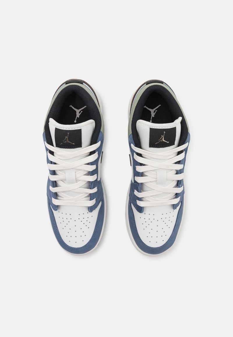 Weiße und marineblaue Sneakers mit perforiertem Zehenbereich, schwarzen Akzenten und Stoffsenkeln. Sie verfügen über ein Logo auf der Zunge und einen strukturierten Kragen.
