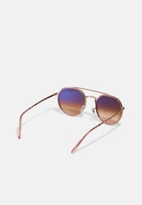Ochelari rotunzi cu ramă roz-aurie, cu lentile degradate de la violet la maro. Au rame subțiri din metal și tamponi pentru nas transparenți. Banchete subțiri și elegante.