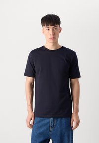 Tricou din bumbac, de culoare bleumarin, cu mânecă scurtă, având guler rotund și un mic detaliu logo pe piept. Purtați-l cu blugi din denim albastru.