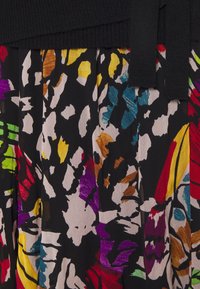 Tissu noir plissé avec un motif floral abstrait coloré comprenant des rouges, jaunes, verts et bleus, surmonté d'une ceinture noire unie.