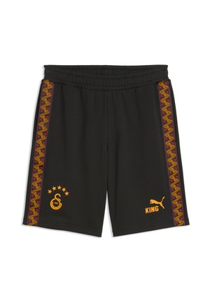 Czarne krótkie spodenki sportowe z elastycznym pasem, dekoracyjnymi wzorzystymi paskami po bokach, pomarańczowym logo Puma oraz tekstem "KING" na prawej nogawce i emblematem drużyny sportowej na lewej nogawce.