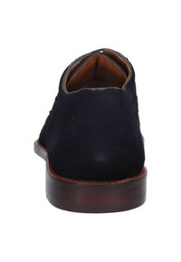 Chaussure en daim bleu marine avec un profil bas, un embout rond et une semelle en cuir. Présente des coutures minimales et une texture lisse. Vue arrière montrée.