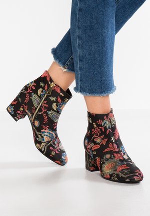 Zwarte enkellaarsjes met multicolore bloemenborduursels, gouden zijrits en blokhak. De stof heeft een gladde textuur met gedetailleerde patronen.