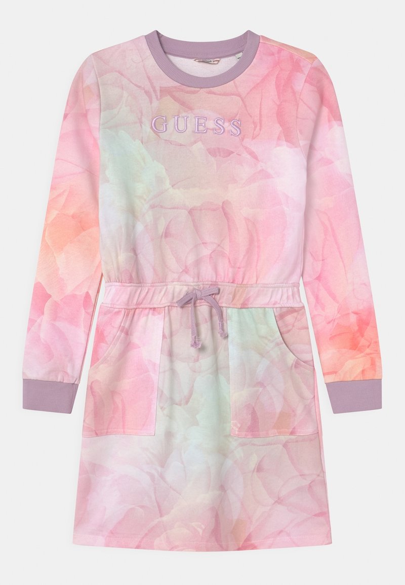 Robe à manches longues de couleur rose pastel, avec un imprimé floral, taille cintrée avec cordon de serrage, et deux poches avant. Logo « GUESS » en lavande.