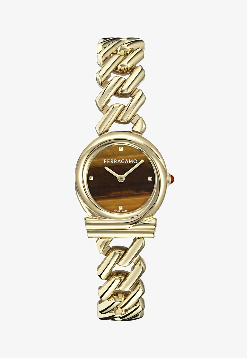 Zelta krāsas rokas pulkstenis ar apaļu korpusu, brūnu rakstainu ciparnīcu un taisnstūra stundu rādītājiem. Ievērojama ķēdīšu dizaina iezīme un sarkans akcenta elements.