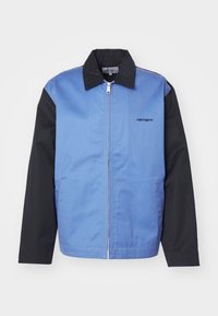 Blå og sort lynlåstrøje med krave, lange ærmer, herrestørrelse og en lille logo på frontens venstre side. Glat stoftekstur.