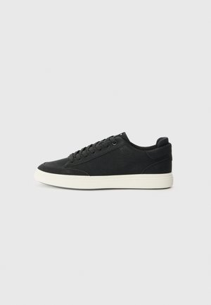 Sorte sneakers med en struktureret overdel, flad hvid gummisål og matchende snørebånd. Har en rund tå og et minimalistisk design.