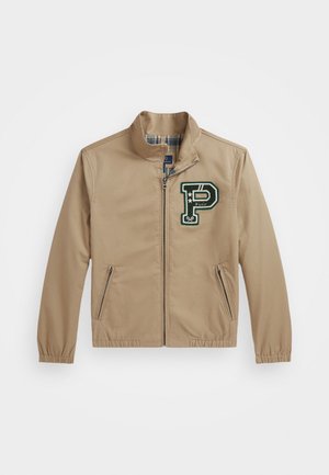 Tan jacket with a stand collar and green embroidered "P" logo. Features zippered pockets and elastic cuffs. Plaid lining visible inside.
