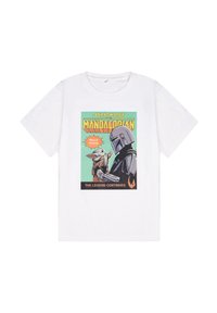 Camiseta blanca de algodón con un estampado gráfico de dos personajes, rodeados de acentos verdes y naranjas, con el texto "Hola Amigo" y "La Leyenda Continúa".