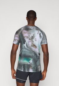 Kurzarm-Sportshirt mit einem strukturierten, abstrakten Design in dunkelgrau, türkis und lila Tönen, Rundhalsausschnitt und Logo auf dem Rücken.