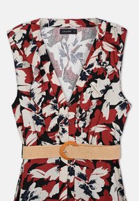 Sleeveless floral dress in red, black, and beige with ruffle details, button front, and a woven beige belt with a round buckle.