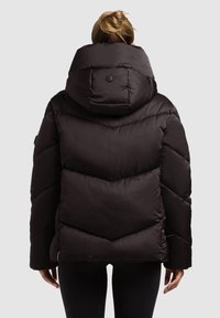 Black puffer jacket with a high collar and button detail, featuring a chevron quilted design and a soft, glossy texture.