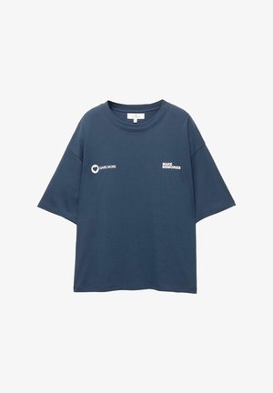 Temno modra prevelika majica s kratkimi rokavi z belim napisom "DARE MORE" in ikono srca na levem prsnem delu ter "MAKE MEMORIES" na desnem prsnem delu.