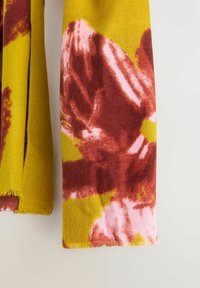 Et rektangulært tørklæde lavet af blødt stof, med en gul baggrund og dristige mønstre i rød, pink og grøn, samt frynset kanter.