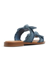 Sandali piatti in denim con cinturini annodati, caratterizzati da una suola in legno marrone e bordi sfrangiati. Design arrotondato con punta aperta e retro scoperto.