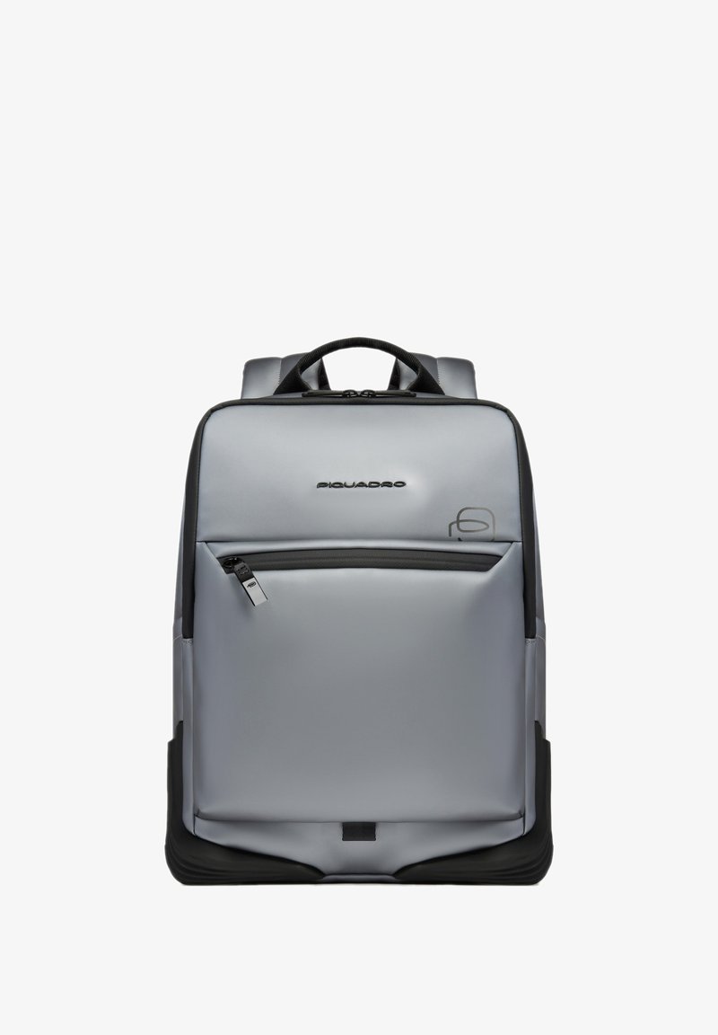 Sac à dos rectangulaire gris avec poche zippée à l'avant, accents noirs, et poignée supérieure, arborant un logo "Piquadro" près du centre supérieur.