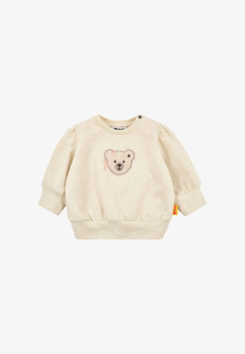 Sweat-shirt pour bébé de couleur crème avec manches bouffantes, taille élastique, et un visage d'ours brodé sur le devant. Doté d'une fermeture à pression.