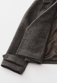 Grijze wollen jas met twee zwarte knopen, puntige revers en een taillé pasvorm. Het interieur heeft een gladde bruine voering en een gestructureerde stof.