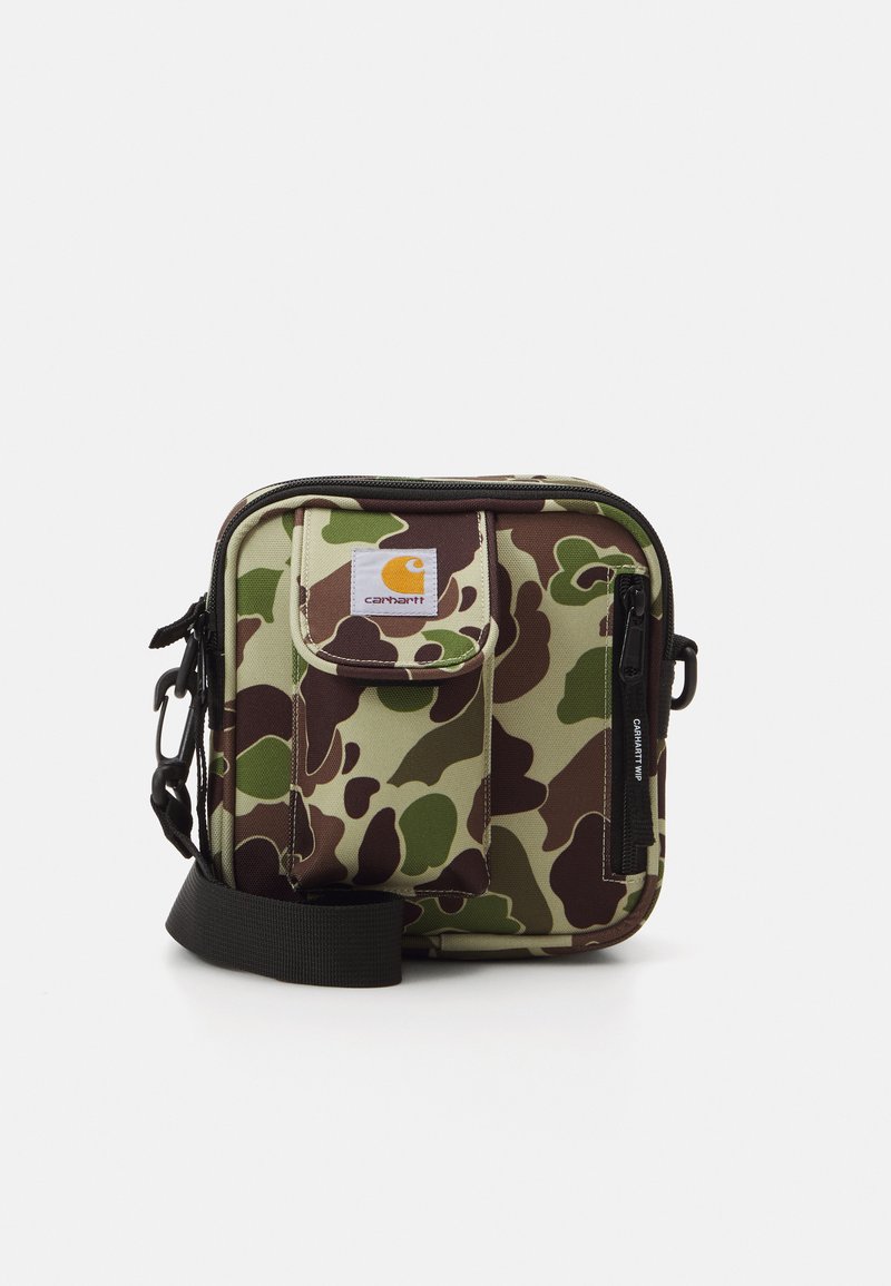 Maskovací crossbody taška vyrobená z odolné tkaniny. Obsahuje zipové kapsy, nastavitelné popruhy a nášivku s logem na přední straně.