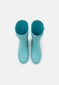 Bottes de pluie en caoutchouc bleu clair avec un extérieur lisse, un bout arrondi et des boucles latérales réglables. Intérieur doublé d'un tissu bleu contrastant.