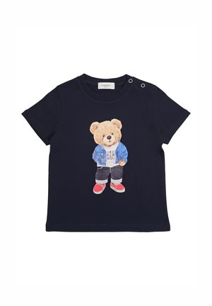 Maglietta per bambini in blu navy con un orsetto che indossa una giacca blu, una camicia bianca, pantaloni neri e sneakers rosse sul davanti.