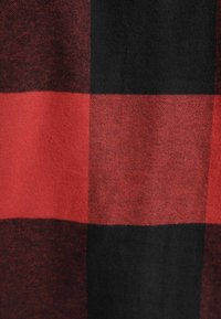 Tessuto a quadri rosso e nero con una consistenza morbida, caratterizzato da grandi quadrati alternati in un motivo robusto.