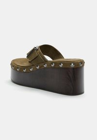 Olive green suede wedge sandals with a thick wooden sole, adorned with silver studs along the edge and a buckle strap on the upper.