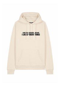 Felpa color crema realizzata in morbido tessuto con tasca frontale e cappuccio regolabile. Il testo nero recita: "DEVO AVERE SUCCESSO PERCHÉ MI PIACCIONO LE COSE COSTOSE."