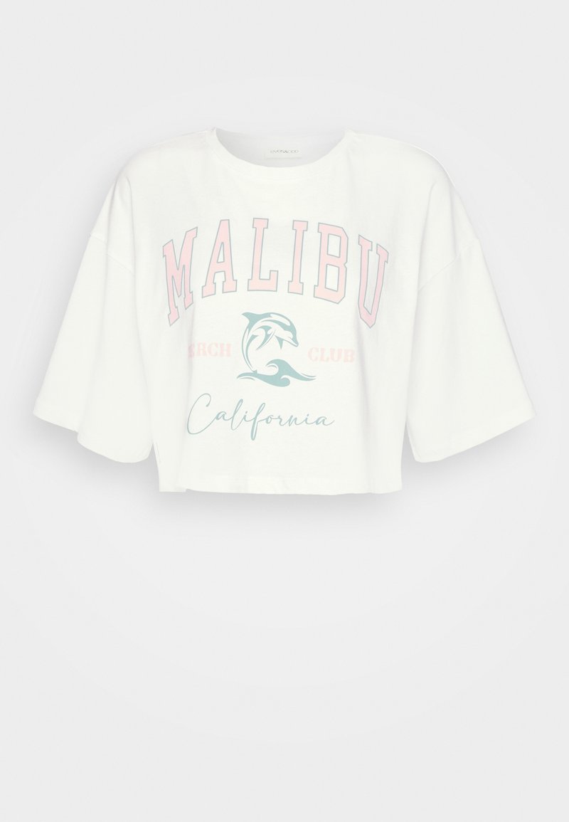 T-shirt blanc court avec des manches larges, texte "MALIBU Beach Club California" et un graphique de dauphin dans des couleurs pastel rose et bleue.