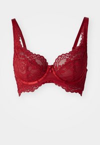 Red lace bra with underwire supports, sheer mesh panels, scalloped edges, and adjustable straps. Features a decorative bow at the center.