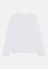 Long-sleeve white cotton T-shirt featuring a rounded neck, simple design, and no visible patterns or hardware. Soft texture.