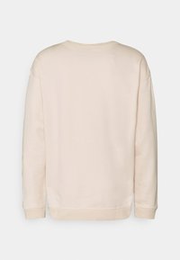 Light beige sweatshirt with a round neck, long sleeves, and ribbed cuffs. Soft texture, relaxed fit, and no visible patterns or graphics.