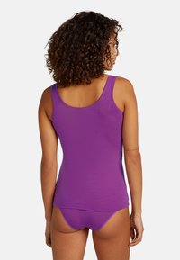 Canotta viola con un design aderente, realizzata in tessuto liscio. Presenta spalline larghe e un collo a barchetta, abbinata a slip coordinati.