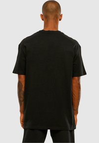 Sort bomulds T-shirt med afslappet pasform, korte ærmer og rund halsudskæring, med glat tekstur og uden synlige grafikker eller detaljer.