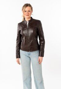 Giacca in pelle marrone con collo alto, chiusura frontale con zip e due tasche laterali; presenta dettagli cuciti e un design aderente.