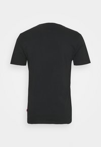 En enfärgad svart t-shirt med kort ärm, visad bakifrån mot en vit bakgrund, utan synliga loggor eller mönster.