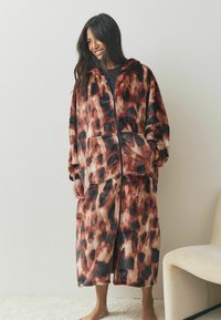 Fleece hoodie-jas in een gemêleerd patroon van bruin, zwart en crème, met een ritssluiting aan de voorkant, twee zakken en een losse pasvorm.