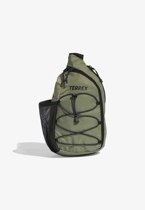 Green TERREX sling backpack with adjustable front bungee cords, zippered main compartment, and black mesh side pocket.