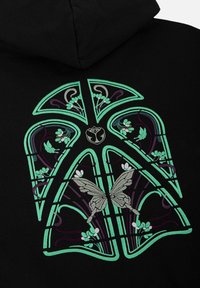 Zwarte hoodie met een groot, geborduurd ontwerp van een glas-in-loodraam in lichtgroen, paars en wit, met bloem- en vlinderdetails.