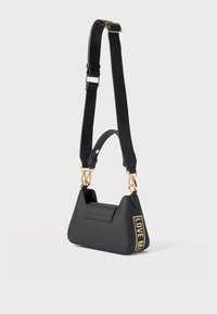 Black faux leather handbag with a structured design, featuring a front pocket, gold hardware, and a strap displaying "LOVE ME" in yellow.