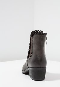 Czarne botki za kostkę z teksturowanej skóry, z falbaniastym wykończeniem, metalowymi oczkami po bokach i dyskretnym zamkiem z tyłu.