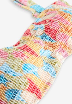 Šarena, pufasta tkanina s živopisnim patchwork uzorkom u ružičastoj, plavoj, zelenoj i žutoj boji. Ima prilagodljive naramenice za bolje prilagođavanje.